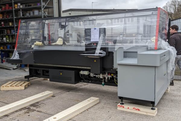 Komax Zeta 650 wire harness machine being positioned outside cable assembly workshop before installation